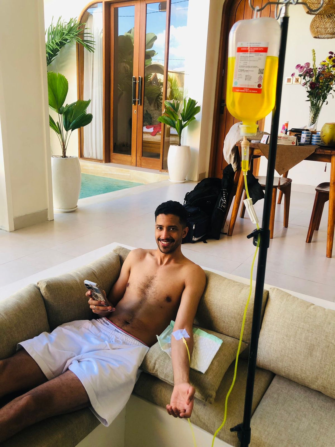 Client smiling during IV drip therapy at Bali villa